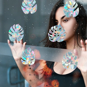 Rainbow prism static cling film featuring monstera leaf shapes on a glass surface