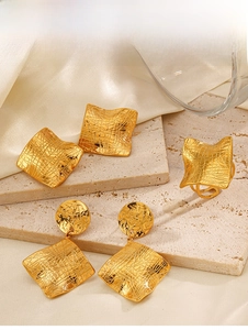 Detail view of gold geometric earrings and ring set with textured hammer finish