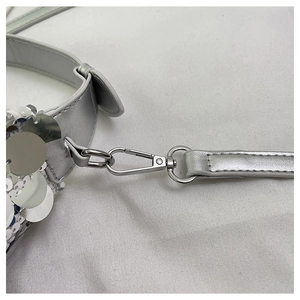 Close-up of silver sequin handbag featuring metallic strap and durable alloy hardware