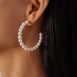 Elegant large hoop earrings with imitation pearls on a model for size perspective