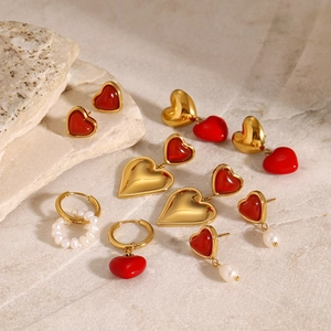 Elegante goldene Herzohrringe und Perlenstecker auf Naturstein, Edelstahl-Schmuck für Damen