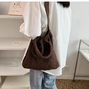 Back view of model wearing a brown knit hobo bag with thick woven texture for casual use