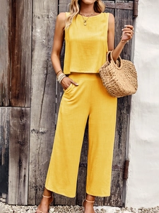 Detail of yellow sleeveless top and wide-leg pants set made of lightweight fabric