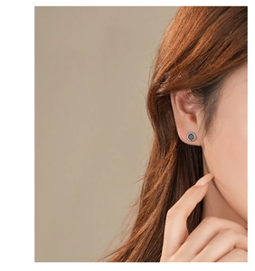 Close-up of minimalist S925 sterling silver black agate stud earring on model's ear