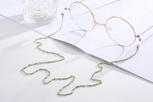 Detail of neon green beaded glasses chain with silver metal links on eyewear