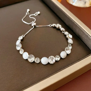 Détail d'un bracelet argenté ajustable avec cristaux et perles sur support en cuir