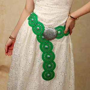 Détail d'une ceinture à disques verts avec boucle argentée ciselée et turquoises