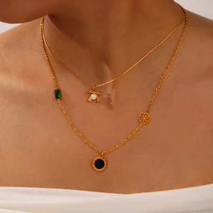 Layered gold titanium necklaces with butterfly pearl charm and Roman numeral disk pendant