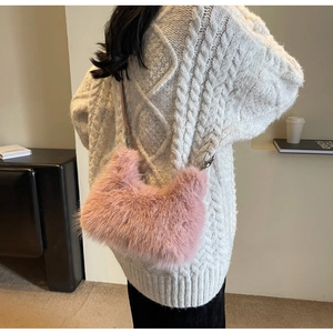 Detail of pink faux fur crossbody hobo bag on model wearing white knit sweater