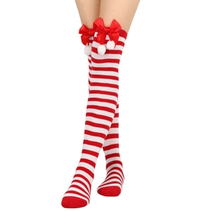 Close-up of festive red and white striped Christmas over-the-knee socks with bows