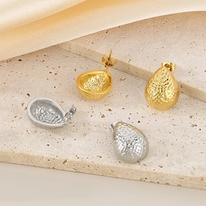 Detail of water drop earrings featuring textured hammered finish in gold and silver