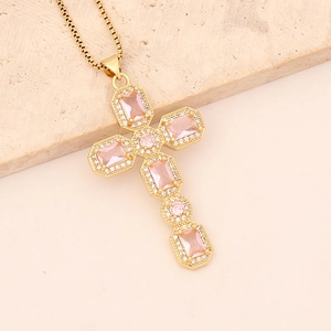 Close-up of a 18K gold cross necklace with pink square and clear round cubic zirconia