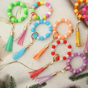Close-up of colorful silicone bead keychains with tassels and golden metal clasps