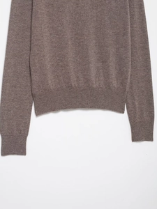 Detailed close-up of dark brown wool blend sweater with ribbed hem and cuffs texture