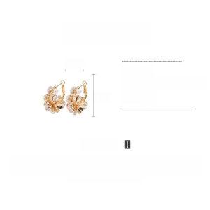 Detailed view of floral stud earrings with pearls and rhinestones measuring 2.5cm by 3cm