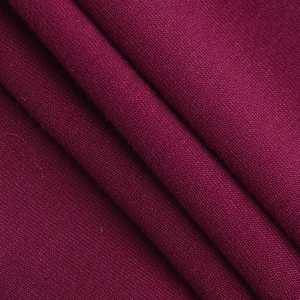 Vue détaillée du tissu en maille rouge vin foncé avec des plis drapés et doux