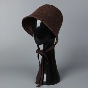 Detailed close-up of brown knitted lace-up sun hat featuring fine texture and bow tie