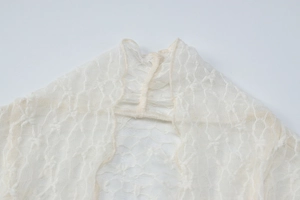 Détail d'un body en dentelle beige montrant les coutures du col et le motif floral délicat