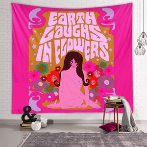 Detail of pink bohemian tapestry with Earth Laughs in Flowers text on a white brick wall
