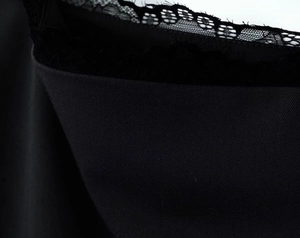 Gros plan sur un tissu noir élégant avec des détails de dentelle fine et de texture