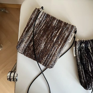 Close-up of woven crossbody mini bag with zip closure and simple wish brand label