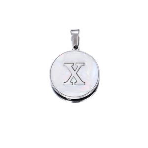 Macro shot of circular pendant featuring white mother-of-pearl and metal letter X inlay