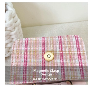 Detail shot of the golden magnetic buckle closure on a pink woven girl's purse