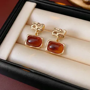 Retro gold plated square resin earrings with amber stones in a jewelry box