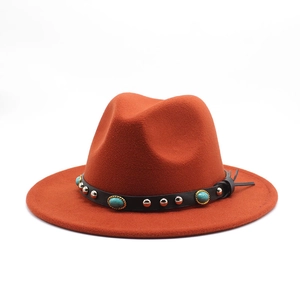 Detail of rust orange wool fedora with turquoise stones and studded leather band