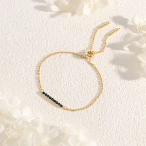 Detail of adjustable gold box chain bracelet with dark blue cubic zirconia stones