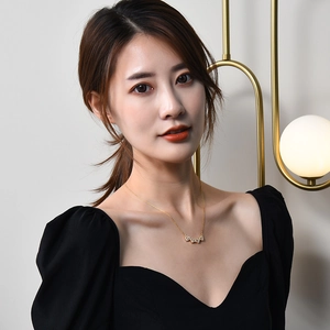 Gold titanium steel necklace with heart elements on a model for luxury fashion styling