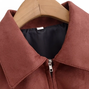 Detail shot of the rust red suede jacket showing the lapel collar and zip closure