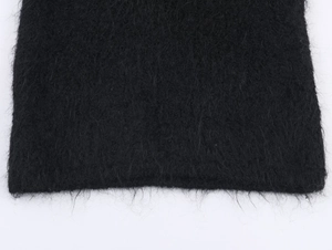Close-up of soft black long-fiber knit fabric with detailed fuzzy mohair texture
