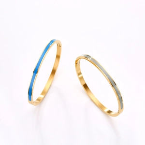 Detailed macro view of gold plated stainless steel bangles with blue and gray enamel inlay