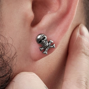 Clou d'oreille vintage en acier inoxydable avec crâne et os porté par un homme