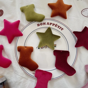 Macro detail of velvet Christmas star and stocking charms for DIY holiday decorations