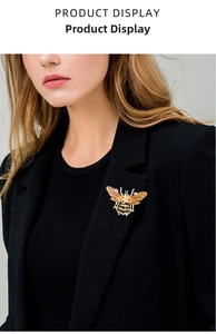 Macro detail of vintage gold bee brooch with inlaid crystals on a black suit lapel