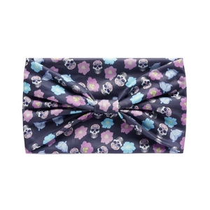 Detail of wide yoga headband featuring sugar skulls and floral bow decoration