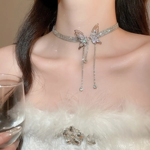 Close-up of sparkling butterfly choker necklace with diamond tassels on model