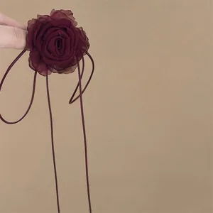 Detail of burgundy lace rose choker with long ribbons and layered chiffon petals