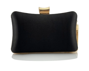 Detail of elegant black satin evening clutch with gold tassel and textured metal clasp