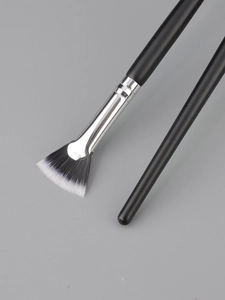 Detail of fan brush with soft synthetic bristles and matte black handle for makeup