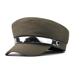 Detail of olive green newsboy cap featuring a silver metallic band with M engraving