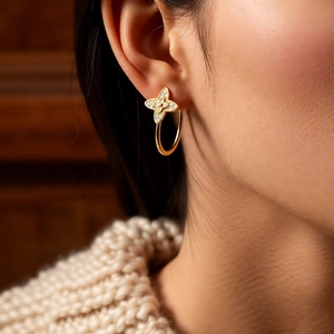 Macro detail of vintage gold C-shape floral earrings with micro-set zircon stones