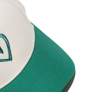 Detail of color-block baseball cap showing fine stitching on visor and heart embroidery