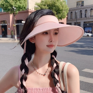 Outdoor close-up of a pink wide brim sun visor hat with stylish open top design