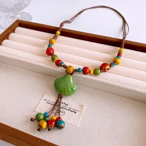 Bohemian colorful ceramic beaded necklace with shell pendant on velvet display