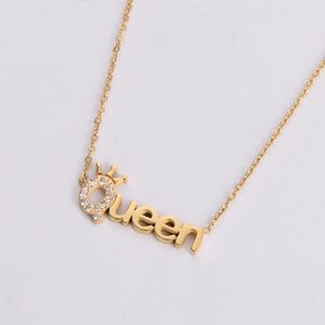 Close-up of golden Queen letter pendant with crown and sparkling white rhinestones