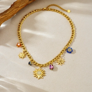 Detailed shot of gold-plated sun and flower charms on a stainless steel NK link chain