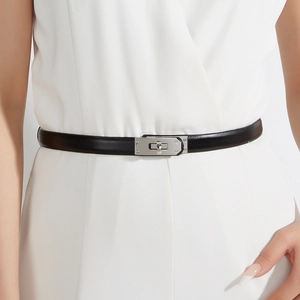 Detail of a thin black leather belt with a silver Kelly lock on a white dress